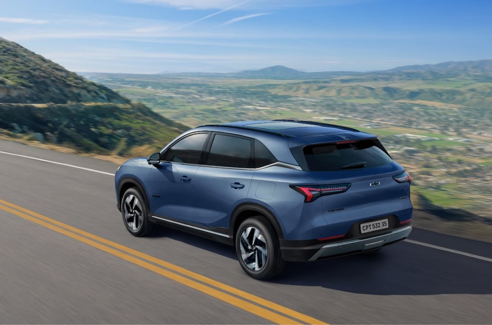 Vista trasera de la Chevrolet Captiva PHEV ascendiendo sobre una ruta elevada, con montañas y naturaleza de fondo. 
