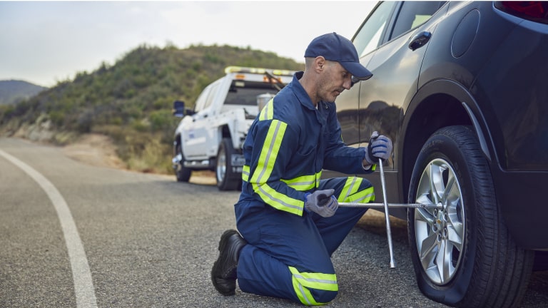 Imagen de un mecánico Chevrolet cambiando una rueda en medio de la ruta.