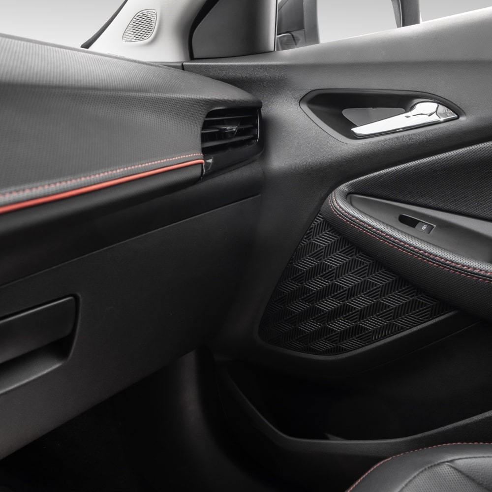 Vista en detalle del panel interior de la puerta de una Chevrolet Montana 2026, con terminaciones en color Jet Black con detalles en rojo y negro High Gloss.