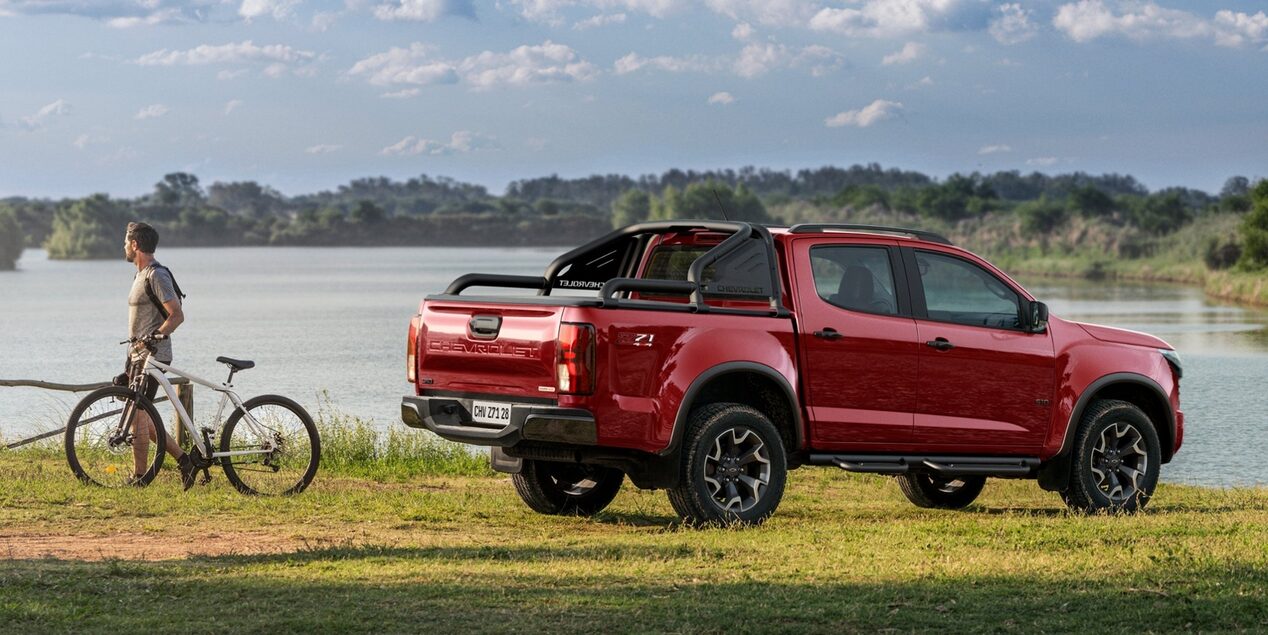 Vista lateral de la Chevrolet S10 Z71 color Rojo Jinx estacionada en la costa de un río.
