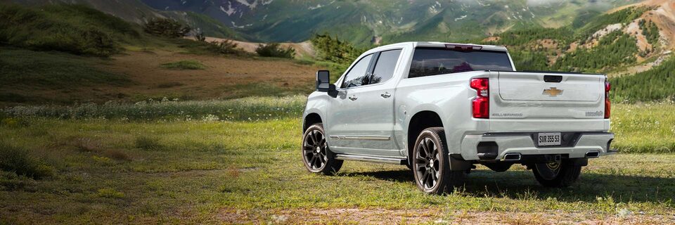 Nova picape Chevrolet Silverado, branco summit, estacionada em um gramado.