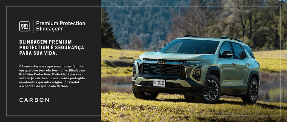 Chevrolet Equinox na cor verde estacionado em campo gramado, com montanhas e árvores ao fundo, sob luz natural.