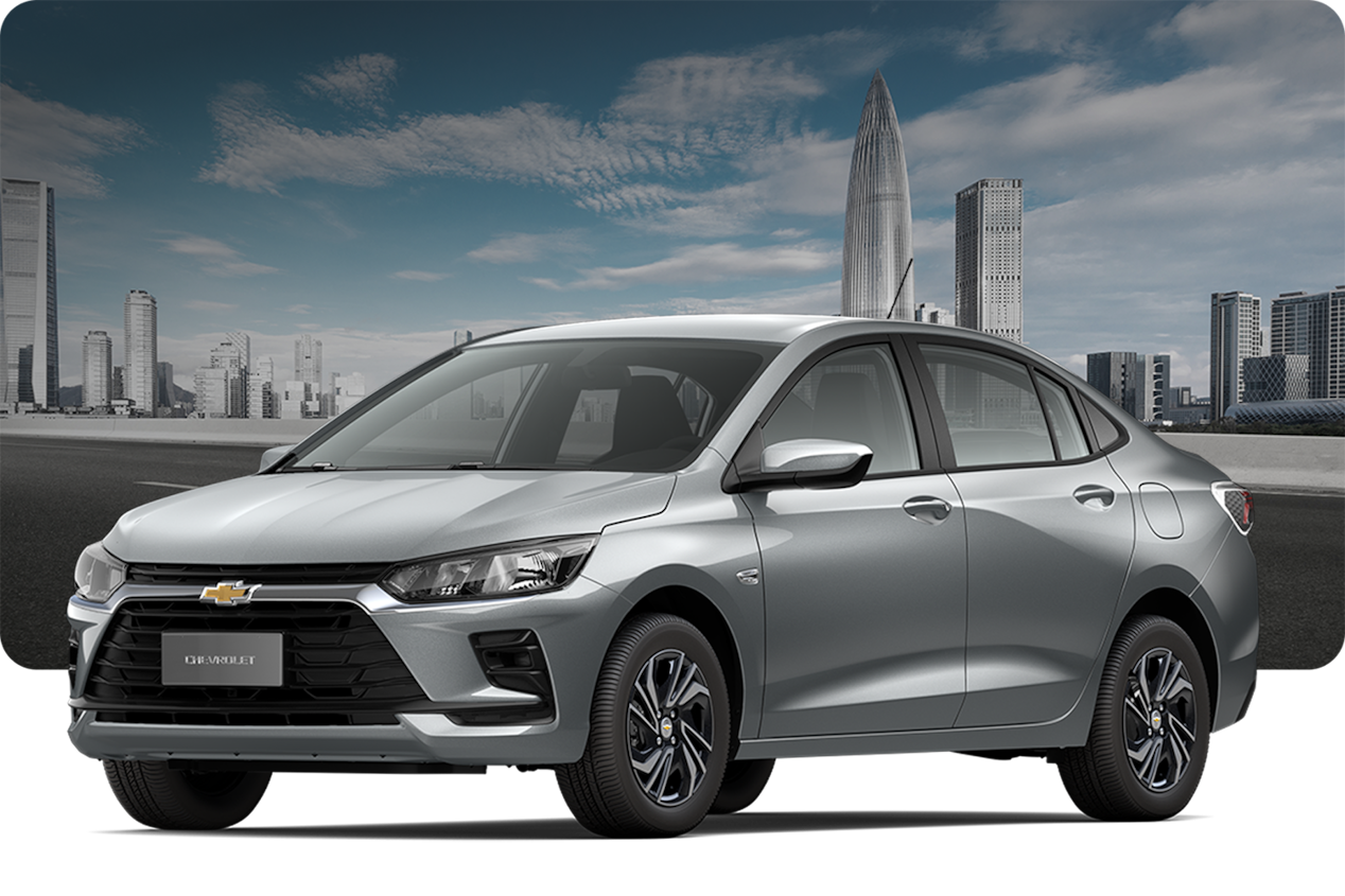 Chevrolet Onix MT na cor Cinza Drake, com fundo de cidade e céu limpo.