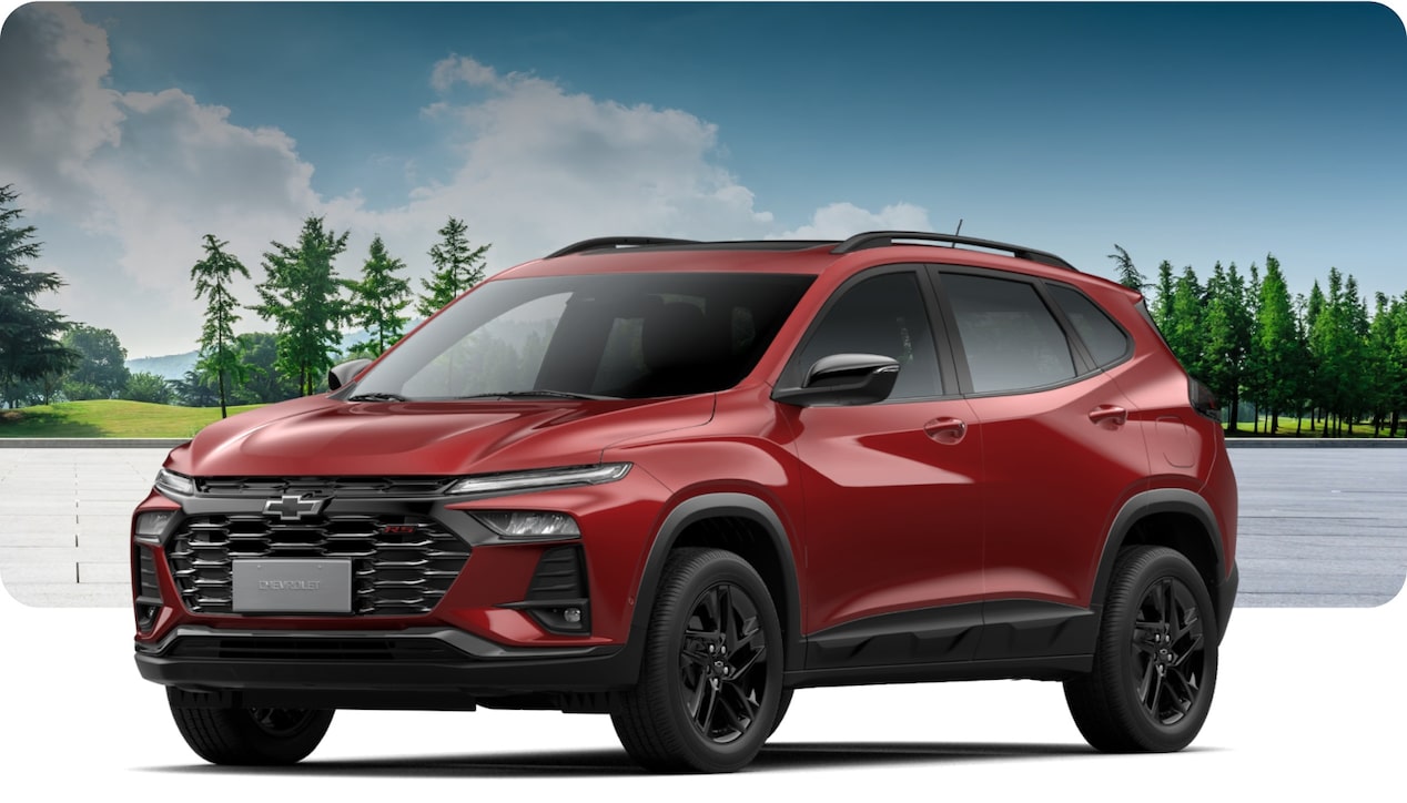 Chevrolet Tracker RS AT Turbo na cor Vermelho Scarlet, em ambiente externo com gramado e céu aberto. 