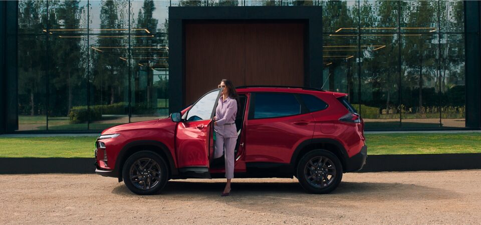 Imagem do Tracker RS AT Turbo estacionado com uma mulher descendo do veículo.