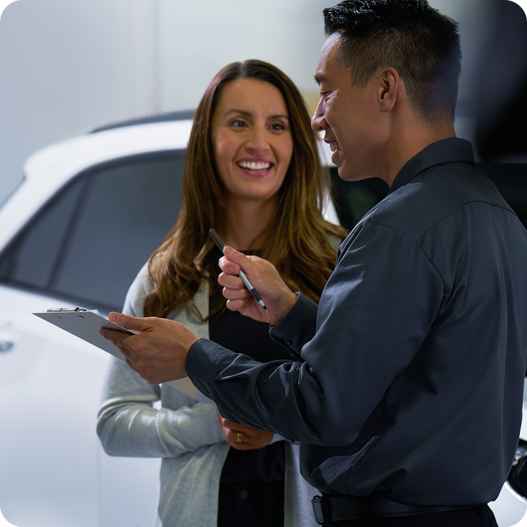 Mulher falando com homem de concessionária