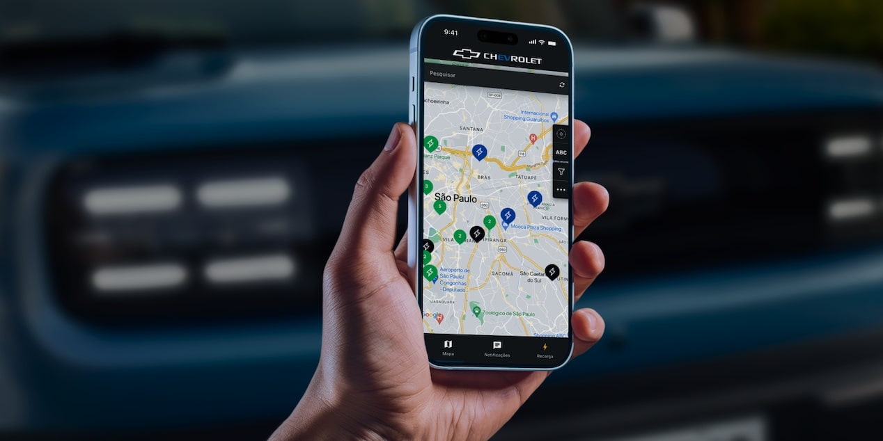 Mão segurando um smartphone com aplicativo de localização de pontos de recarga.