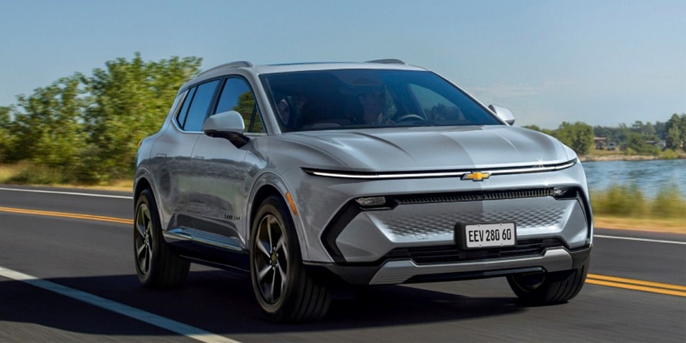 Chevrolet Equinox EV em imagem ambientada. O SUV aparece em movimento sobre um tapete de asfalto também conhecido como estrada, ilustrado toda a sua potência e rendimento.