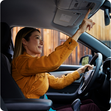 Mulher no carro apertando o botão de OnStar
