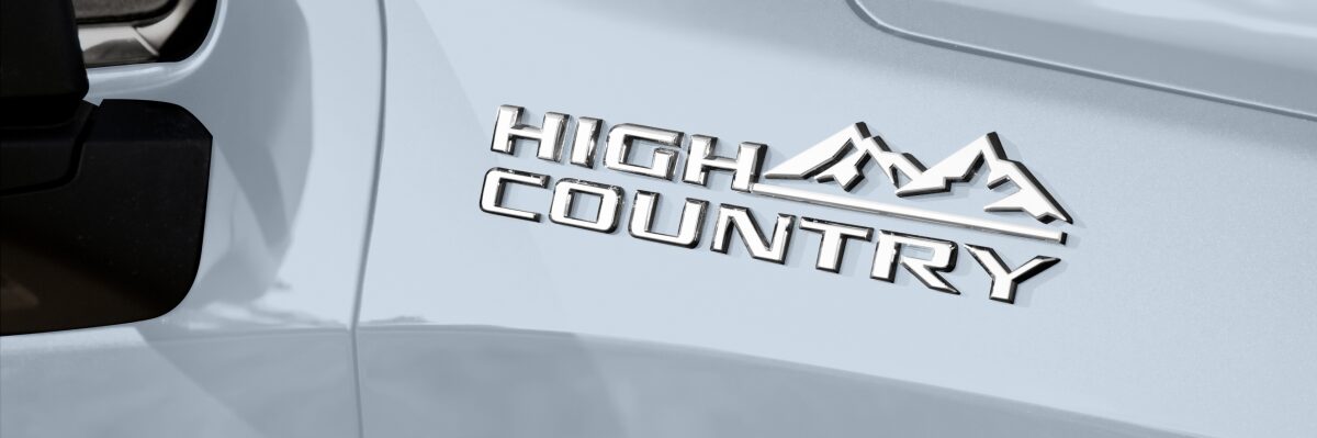 Detalhe do logo high Country instalado na lateral da Chevrolet Silverado em fotografia ambientada para a página de acessórios originais da respectiva picape.