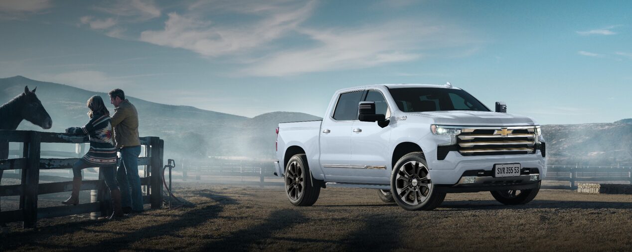 Banner versão desktop da página de acessórios da Chevrolet SIlverado. A picape aparece em imagem ambientada diante de uma cerca onde um casal se aproxima de um cavalo, remetendo à vida no campo.