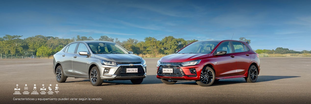Chevrolet Onix Sedan y Chevrolet Onix con vegetación de fondo.