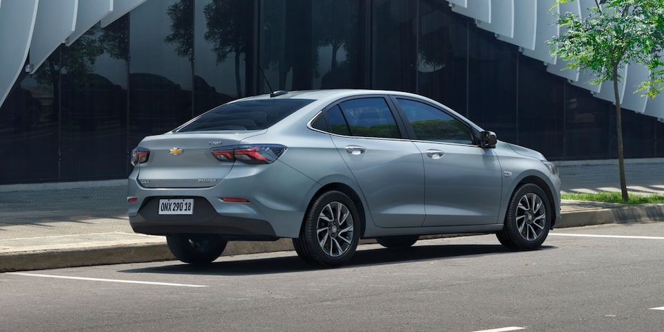 Vista trasera lateral del Chevrolet Onix Sedán estacionado en área urbana.