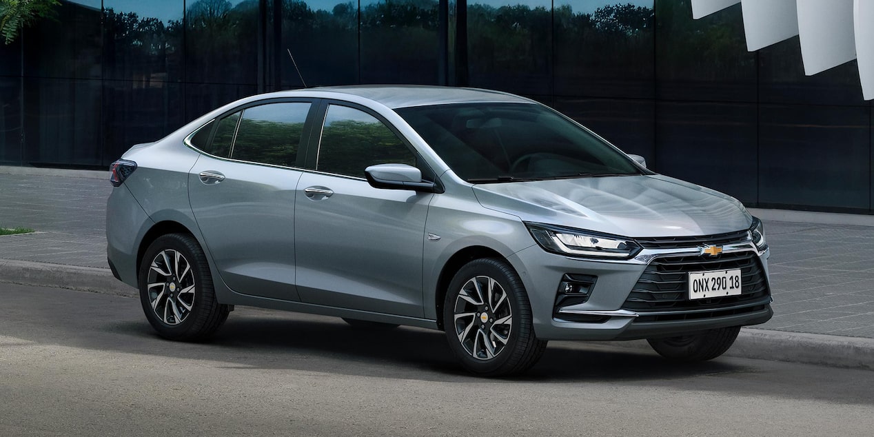 Vista lateral del Chevrolet Onix Sedán parqueado en zona urbana.