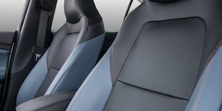 Interior del Chevrolet Onix Sedán Premier AT, destacando los asientos delanteros con detalles en color azul y gris de ecocuero premium.