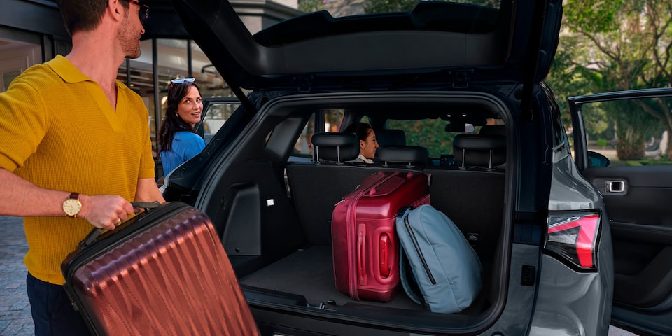 Maletera abierta completamente de la Chevrolet Captiva EV con una familia guardando maletas.