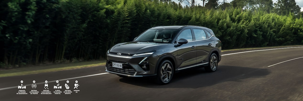 Nueva Chevrolet Capitva EV circulando por un camino con vegetación de fondo.