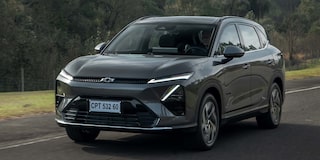 Vista frontal de la Chevrolet Captiva EV circulando por una carretera con vegetación de fondo.