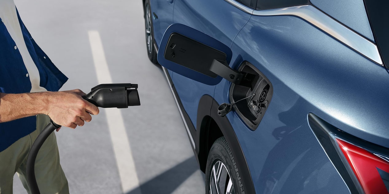 Imagen de una mano a punto de enchufar un cargador eléctrico en la Chevrolet Captiva PHEV.