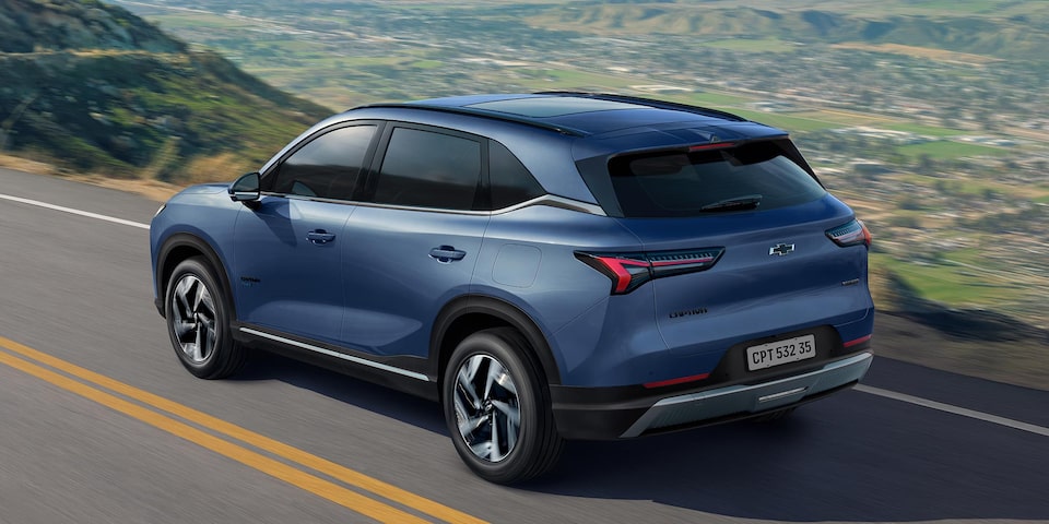 Vista trasera de la Chevrolet Captiva PHEV ascendiendo sobre una ruta elevada, con montañas y naturaleza de fondo. 