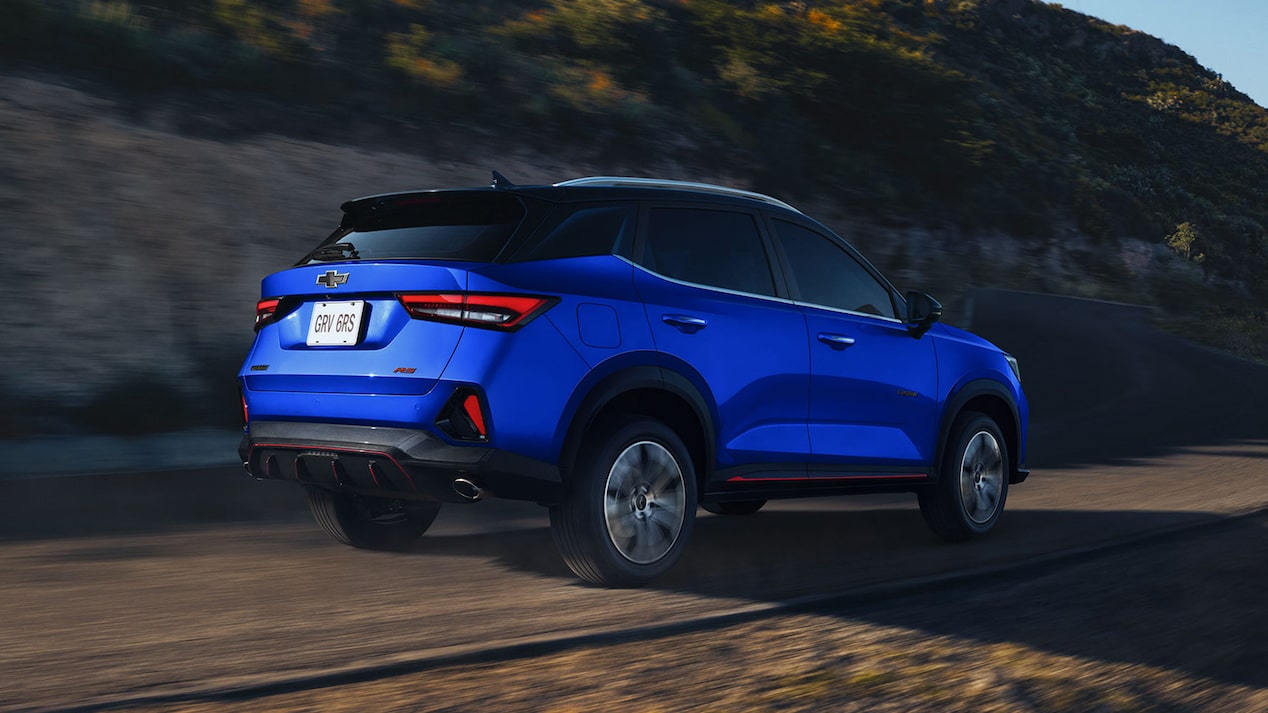 Vista trasera de una Chevrolet Groove RS circulando sobre una carretera de tierra en la montaña.