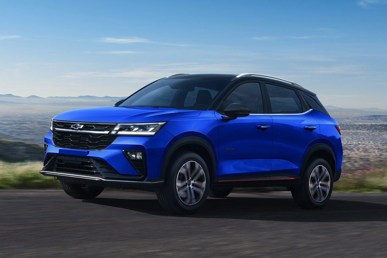 Chevrolet Groove en una carretera panorámica sobre la cima de un mirador. De fondo se pueden ver casas y montes a la distancia. 