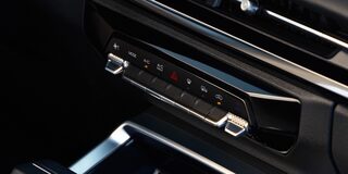 Controles del aire acondicionado digital de la Chevrolet Groove, con botones táctiles y detalles cromados ubicados bajo la pantalla central del sistema de infoentretenimiento.