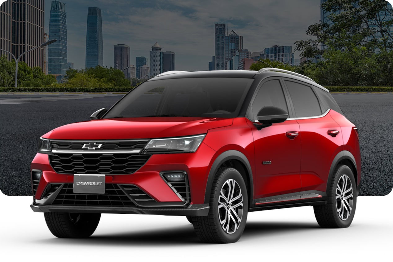 Chevrolet Groove modelo RS en color Rojo Metálico sobre un fondo urbano con edificios y árboles.