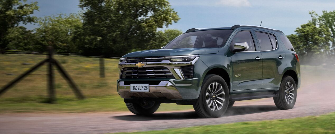 Chevrolet Trailblazer circulando por un camino de tierra con vegetación de fondo.