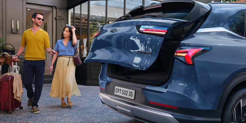 Una pareja acercándose a la Chevrolet Captiva PHEV para guardar sus pertenencias en el maletero.