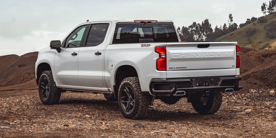 Vista trasera de una Chevrolet Silverado, estacionada en un camino de ripio.