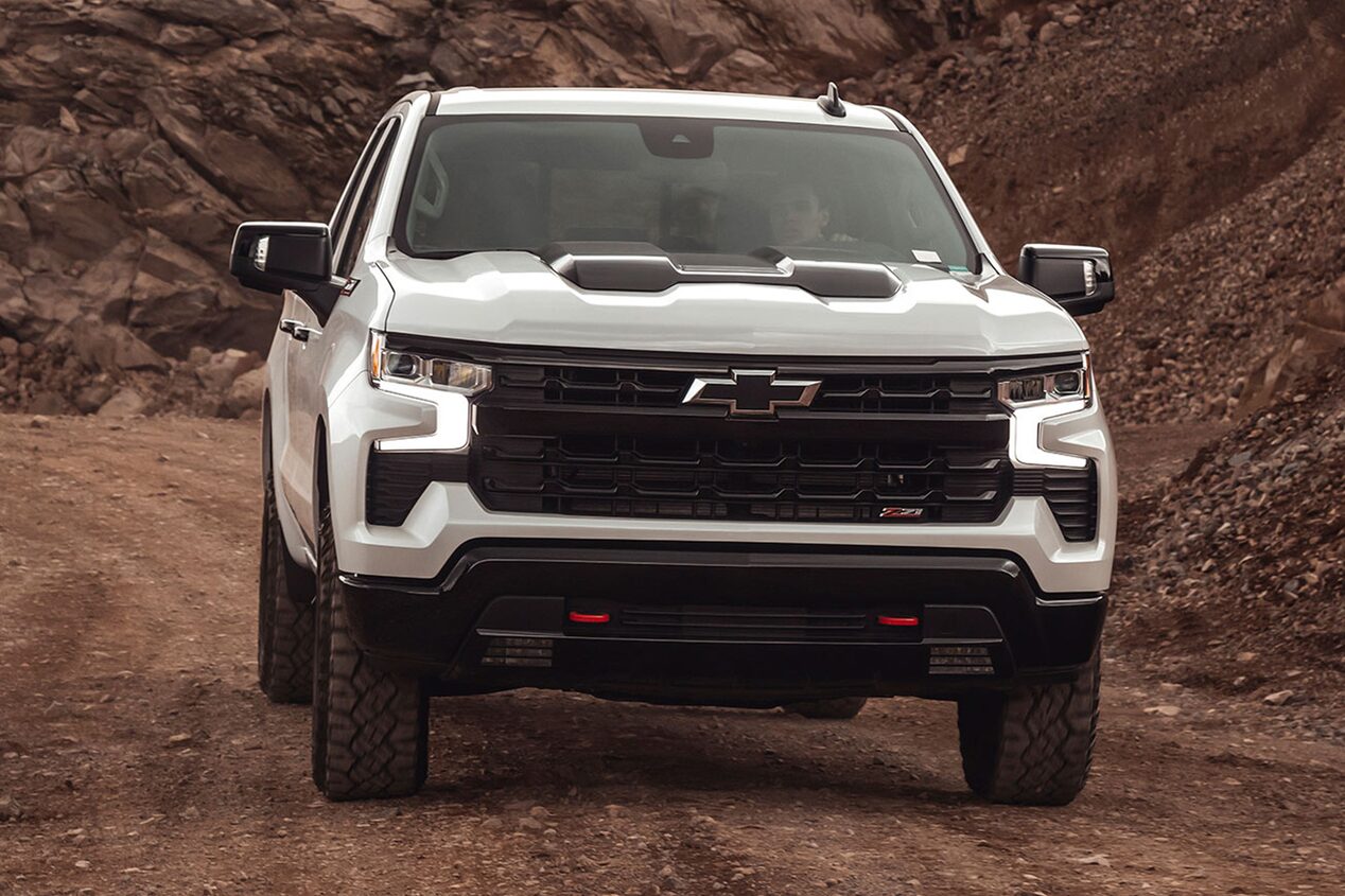 Chevrolet Silverado andando sobre un camino de ripio, rodeada de piedras.