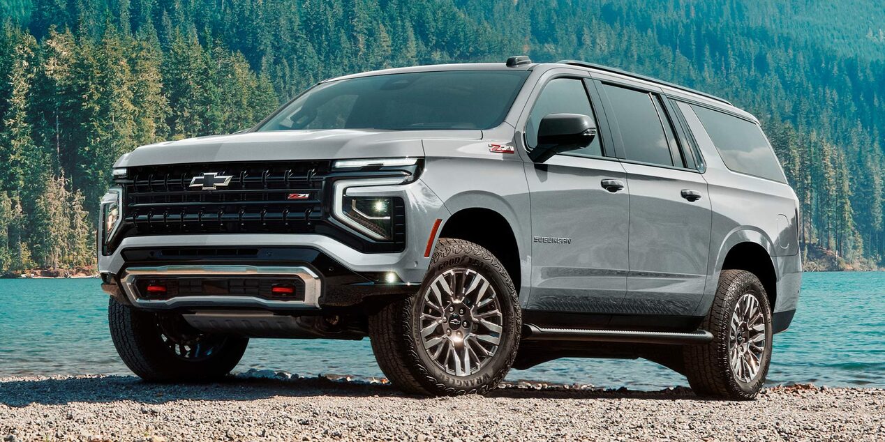 Chevrolet Suburban Z71 estacionada a la orilla de un lago al pie de una montaña.