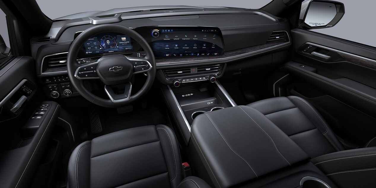 Vista interior de la Chevrolet Suburban Z71, mostrando su tablero: volante, pantalla central y controles.