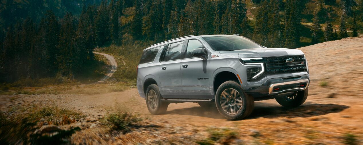 Chevrolet Suburban 2026 avanzando por un camino de tierra en la montaña.