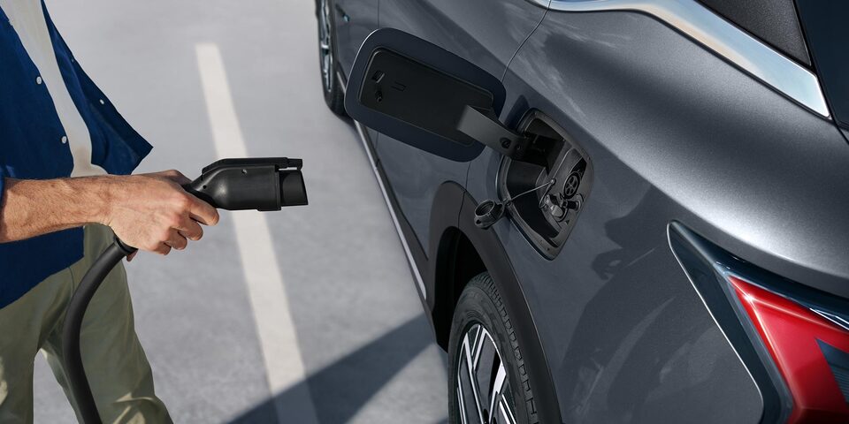 Hombre recargando la Chevrolet Captiva EV en una estación de carga.